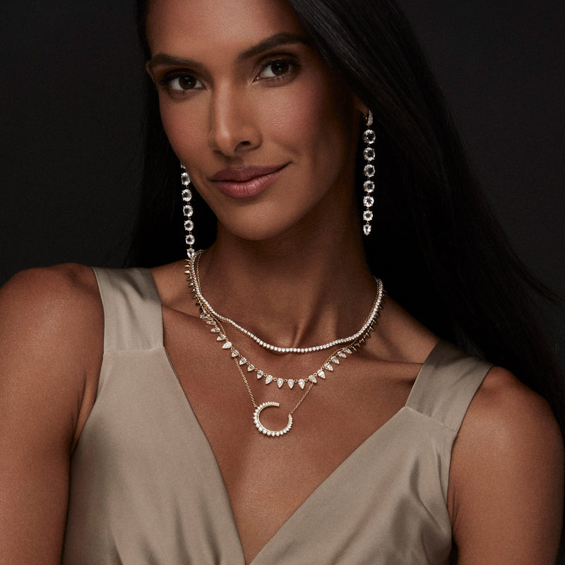 Model wearing Topaz Drop Earrings, Diamond Tennis Necklace, Baguette Diamond Pear Shaped Necklace, Diamond Moon Necklace