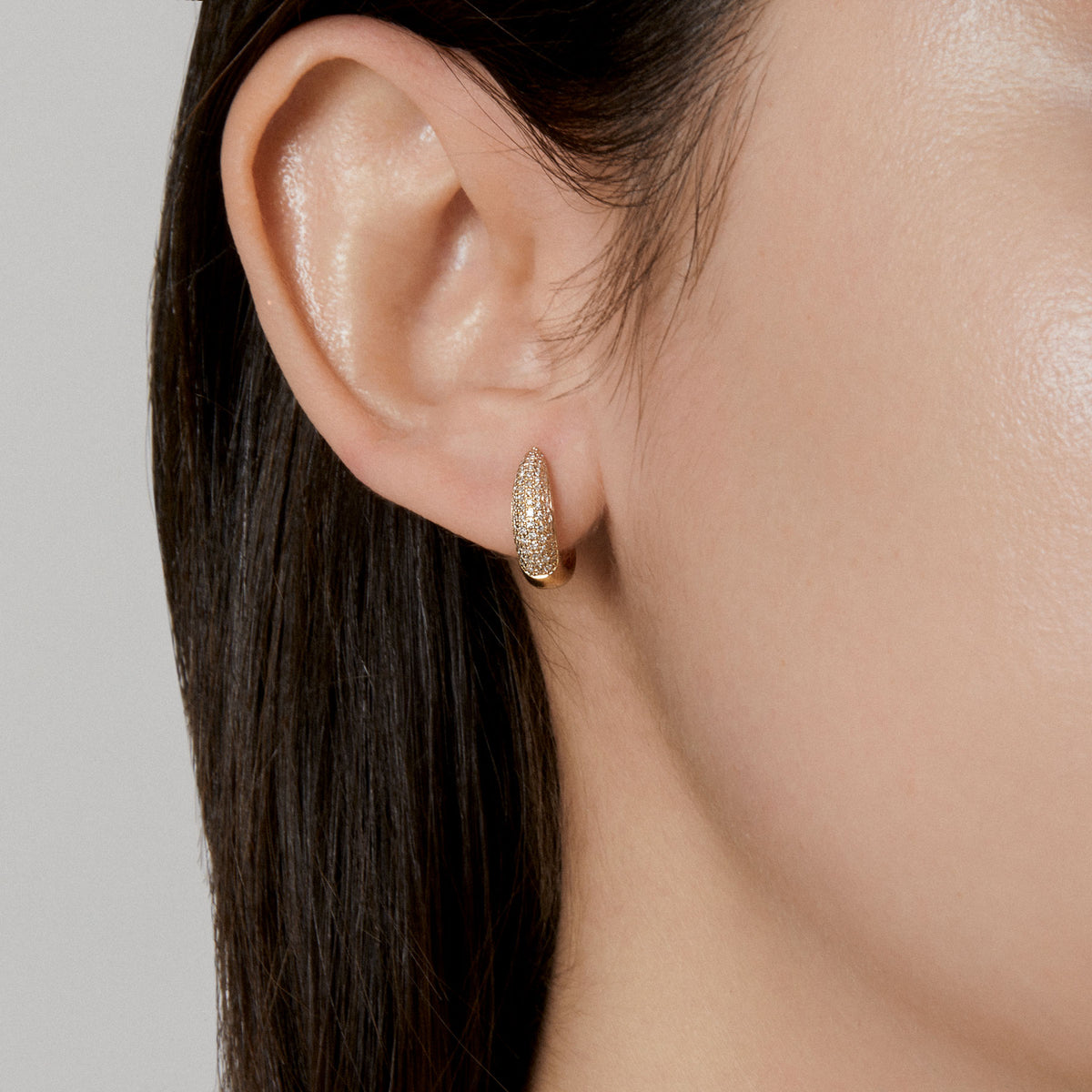 Model wearing 14KT Yellow Gold Diamond Gwyneth Huggie Earrings