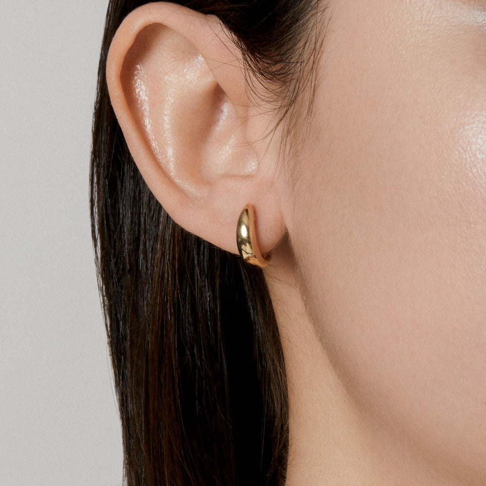 Model wearing 14KT Yellow Gold Gwyn Huggie Earrings