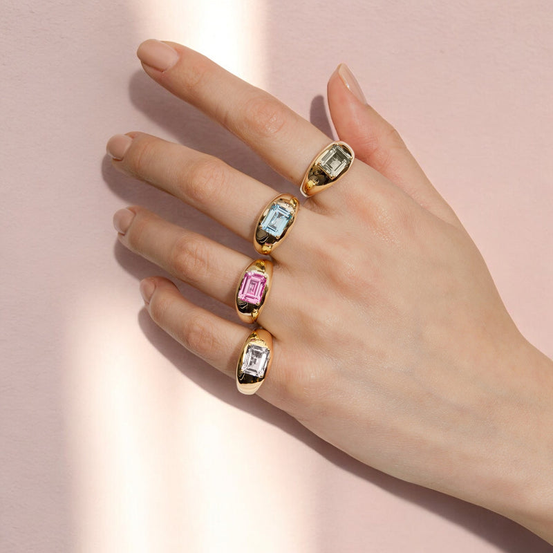 Model wearing white topaz, pink topaz, blue topaz, green amethyst aperitif rings